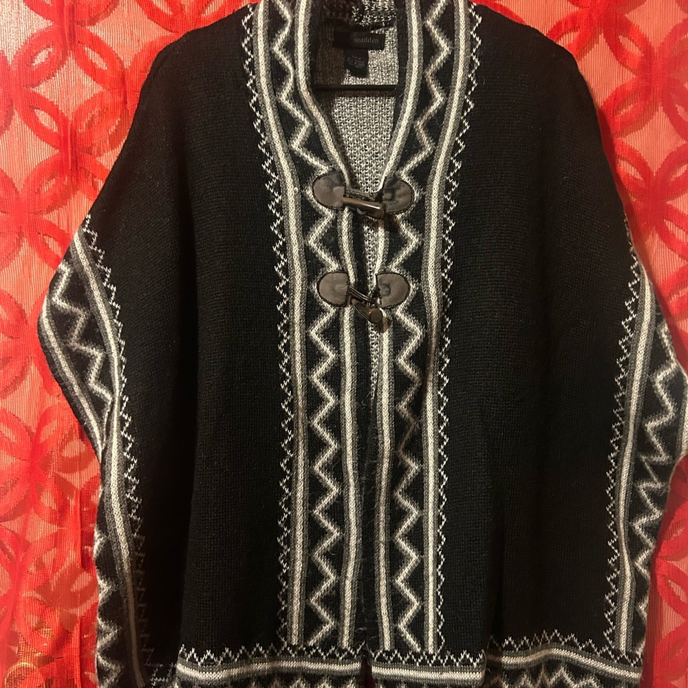 Black and white knit ruana with a hook button closure.#winterfashion